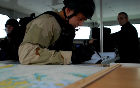 US Navy 091010-N-1688B-189 Boatswain's Mate 2nd Class Brandon Carney, assigned to the guided missile destroyer USS Cole (DDG 67), reviews paperwork during a visit, board, search and seizure (VBSS) exercise
