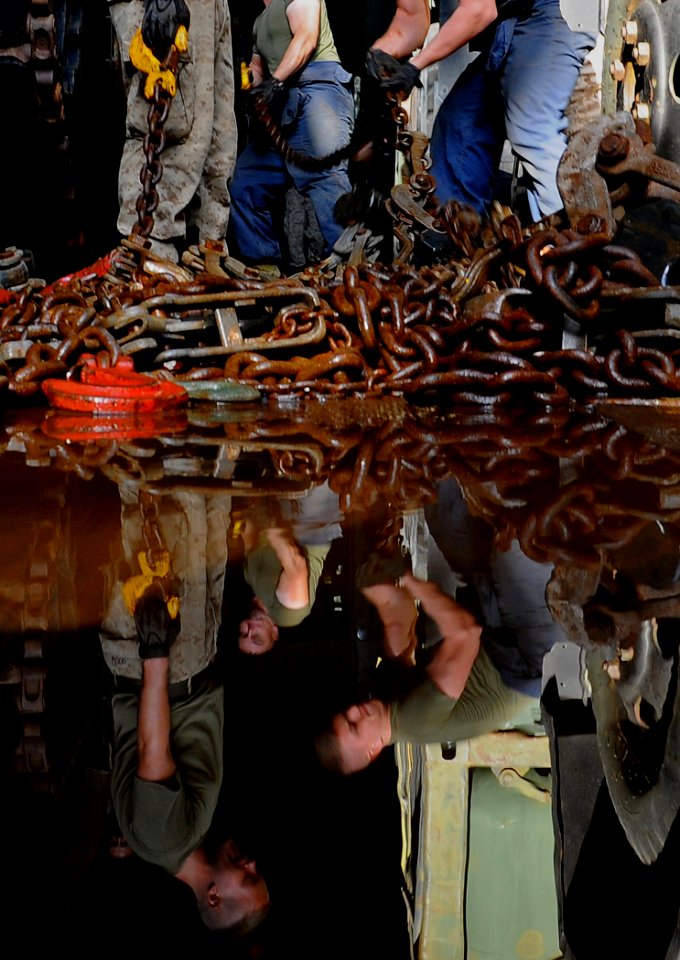 US Navy 091010-N-1831S-032 Marines from 22nd Marine Expeditionary Unit (22nd MEU) move tie-down chains inside the well deck of the amphibious dock landing ship USS Fort McHenry (LSD 43)