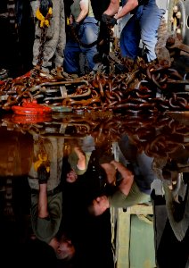 US Navy 091010-N-1831S-032 Marines from 22nd Marine Expeditionary Unit (22nd MEU) move tie-down chains inside the well deck of the amphibious dock landing ship USS Fort McHenry (LSD 43)