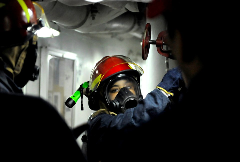 US Navy 091009-N-7280V-129 Information Systems Technician 3rd Class Jonetta McCoy charges the hose during a flying squad drill aboard the amphibious command ship USS Blue Ridge (LCC 19)