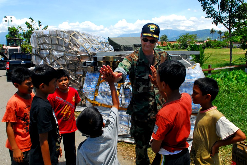 US Navy 091010-N-9123L-026 Commander, Amphibious Force Seventh Fleet, Rear Adm. Richard Landolt meets with some children outside the Humanitarian Assistance Rapid Response Team medical tent in Padang, Indonesia
