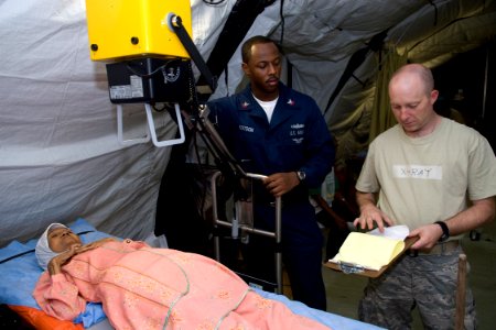 US Navy 091012-N-9123L-045 Hospital Corpsman 2nd Class Alvin Cotson and Air Force Sgt. Clifford Gentry prepare to X-ray a patient at the Humanitarian Assistance Rapid Response Team (HARRT) medical facility in Padang, Indonesia photo