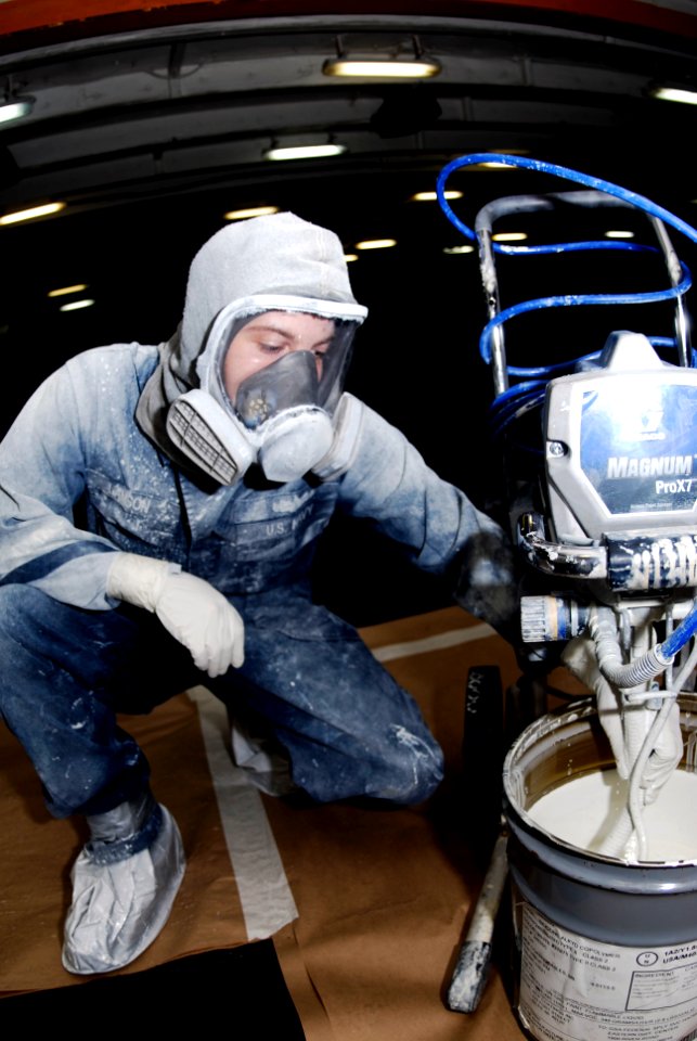 US Navy 091011-N-8960W-013 Boatswain's Mate Seaman Brandon Lamson mixes paint in the forecastle aboard the aircraft carrier USS Nimitz (CVN 68)
