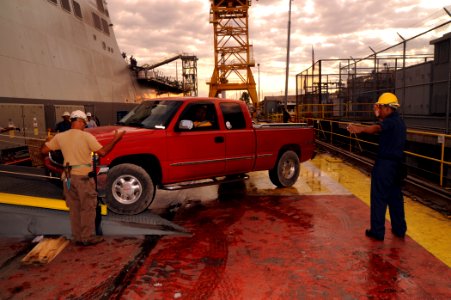 US Navy 091010-N-2147L-001 Boatswain's Mate 3rd Class Franklin Rendo directs vehicles aboard the amphibious transport dock ship Pre-Commissioning Unit (PCU) New York (LPD 21)