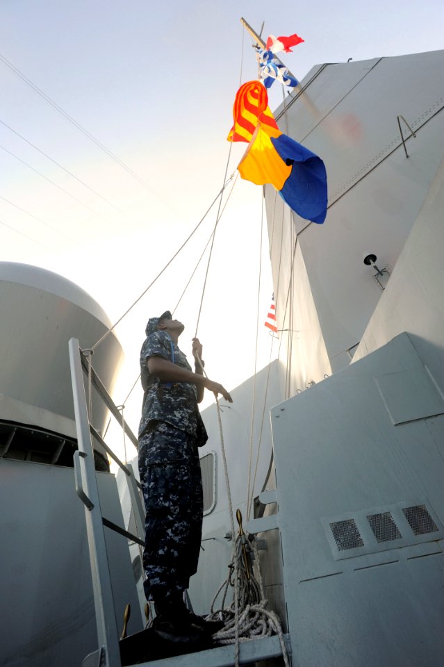 US Navy 091013-N-2147L-002 Quartermaster Seaman Jason Lightburn raises the international call sign of the amphibious transport dock ship Pre-Commissioning Unit (PCU) New York (LP D21)