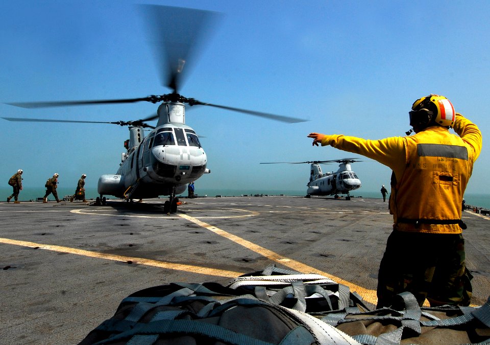 US Navy 091011-N-0807W-021 Boatswain's Mate 3rd Class Kyle E. Eggering directs Navy and Marine Corps personnel aboard a Marine Corps CH-46 helicopter