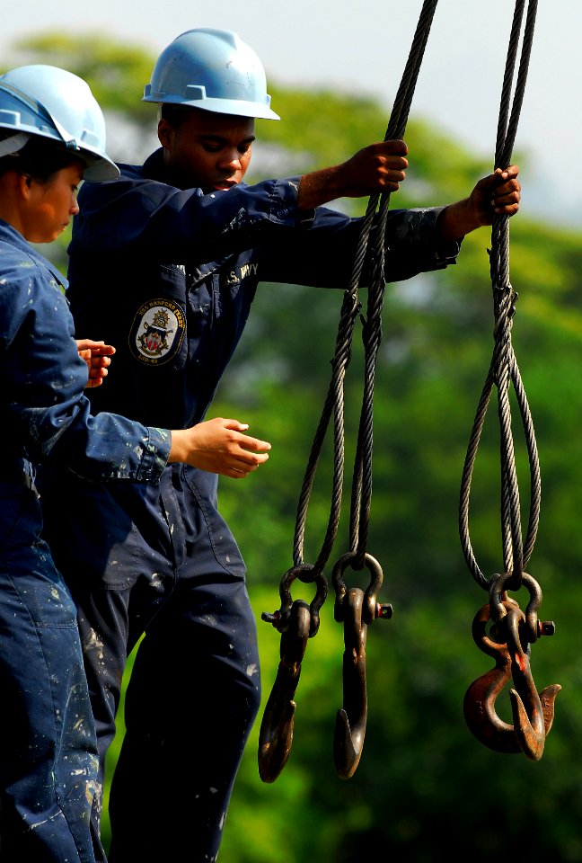 US Navy 091012-N-0807W-145 Seaman Joseph B. Davis and Seaman Rhoda O. Fantone prepare to crane off U.S. Marine Corps equipment from the amphibious dock landing ship USS Harpers Ferry (LSD 49)
