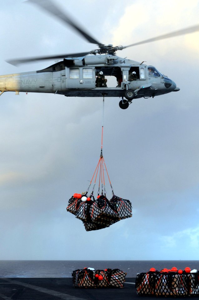 US Navy 091012-N-9132C-023 An MH-60S Sea Hawk helicopter, assigned to the Blackjacks of Helicopter Sea Combat Squadron (HSC) 21, loads cargo onto the flight deck of the aircraft carrier USS Ronald Reagan (CVN 76)