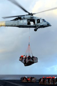US Navy 091012-N-9132C-023 An MH-60S Sea Hawk helicopter, assigned to the Blackjacks of Helicopter Sea Combat Squadron (HSC) 21, loads cargo onto the flight deck of the aircraft carrier USS Ronald Reagan (CVN 76)