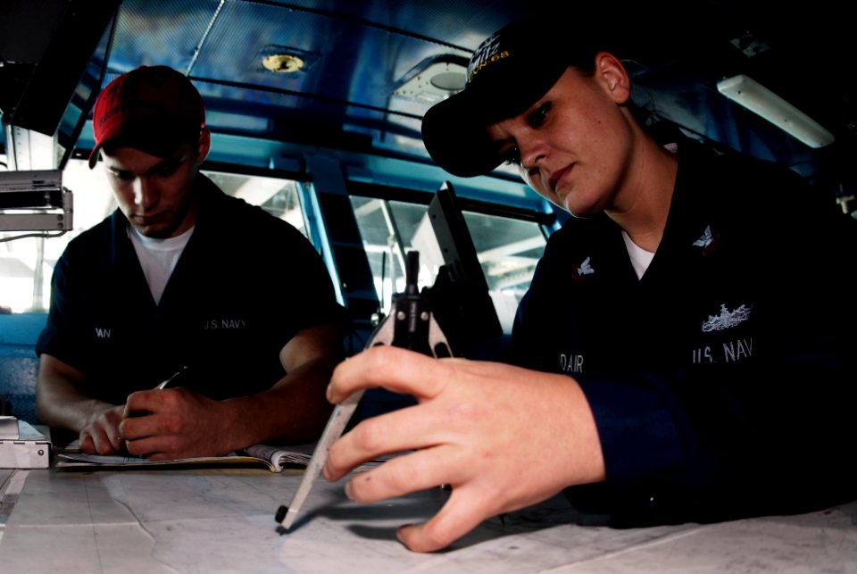 US Navy 091012-N-8960W-004 Operations Specialist 2nd Class Brittany Addair and Seaman David Mahan plot a course on the bridge of the aircraft carrier USS Nimitz (CVN 68)
