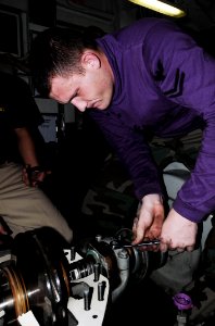 US Navy 091014-N-3038W-203 Aviation Boatswain's Mate (Fuels) 2nd Class Michael Foster performs maintenance on a fuel pump in the number ^2 pump room aboard the aircraft carrier USS Nimitz (CVN 68) photo