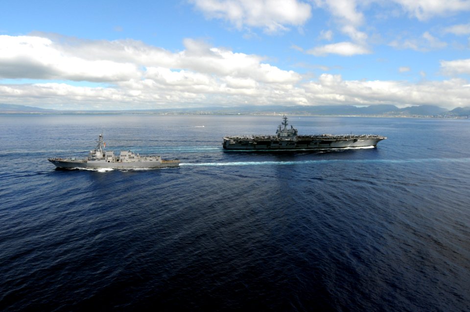 US Navy 091013-N-1635S-001 The aircraft carrier USS Ronald Reagan (CVN 76) passes by the guided-missile destroyer USS Chafee (DDG 90) while approaching Pearl Harbor, Hawaii for a scheduled port visit