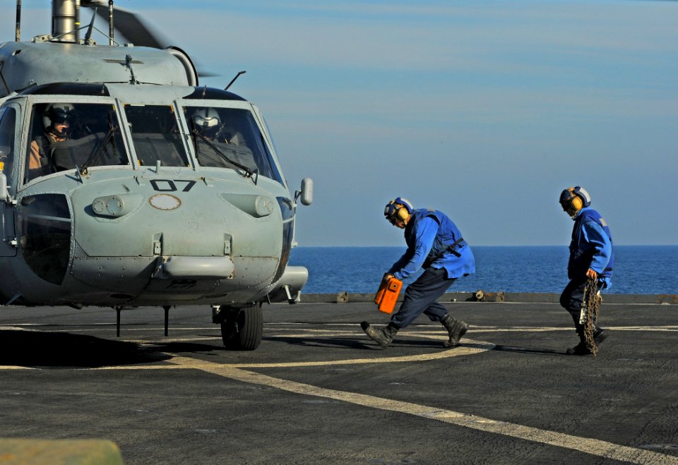 US Navy 091013-N-1831S-033 Seaman Michale Sturdevant and Boatswain's Mate 3rd class Kelly George run to secure an MH-60S Sea Hawk helicopter from the Sea Knights of Helicopter Sea Combat Squadron (HSC) 22