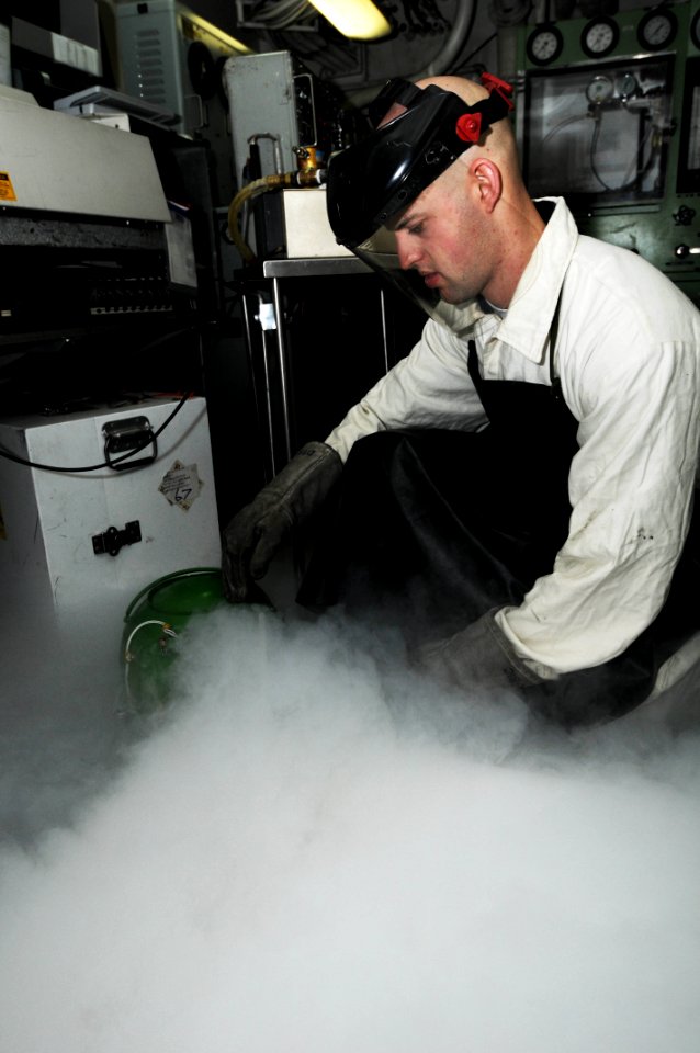 US Navy 091013-N-3038W-070 Aircrew Survival Equipmentman 2nd Class Andrew Wardell, assigned to the aircraft carrier USS Nimitz (CVN 68), empties liquid oxygen bottles