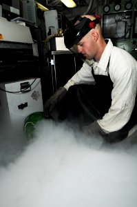 US Navy 091013-N-3038W-070 Aircrew Survival Equipmentman 2nd Class Andrew Wardell, assigned to the aircraft carrier USS Nimitz (CVN 68), empties liquid oxygen bottles