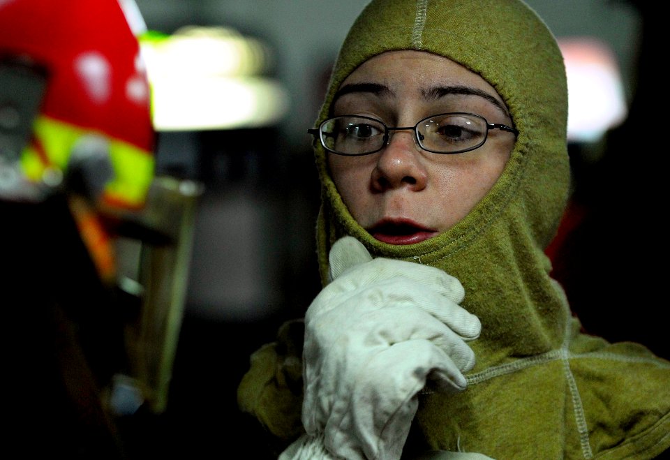 US Navy 091013-N-0807W-028 Culinary Specialist 3rd Class Tyrney M. Fisher relays a status update message to a fire party member during a simulated fire drill aboard the amphibious dock landing ship USS Harpers Ferry (LSD 49)