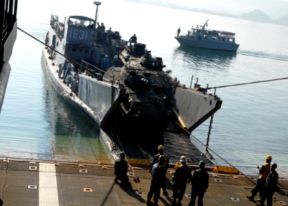 US Navy 091013-N-6692A-027 Sailors and Marines offload Marine Corps vehicles from the amphibious dock landing ship USS Tortuga (LSD 46) onto a landing craft utility (LCU) photo