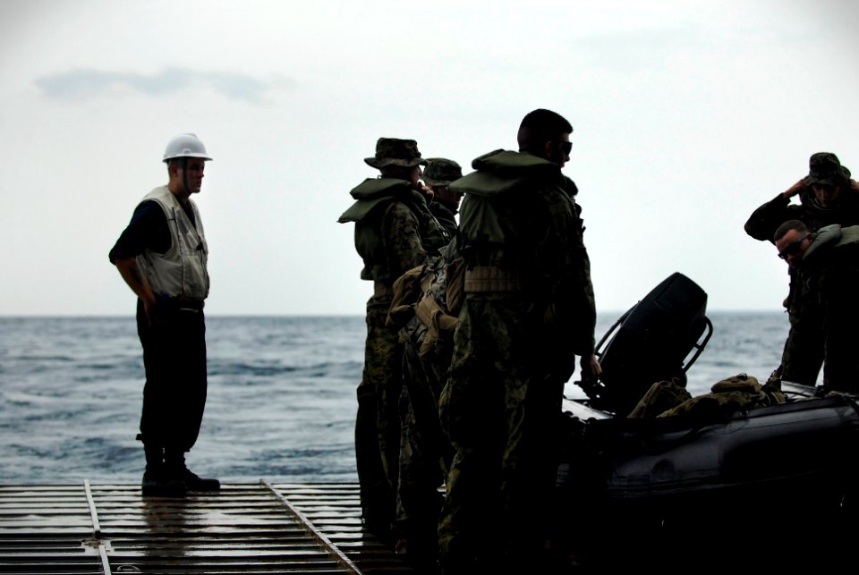 US Navy 091014-N-0807W-129 Boatswain's Mate 3rd Class Brandon S. Clemets stands by to help Marines safely disembark during a ship-to-shore combat rubber raid craft offload exercise