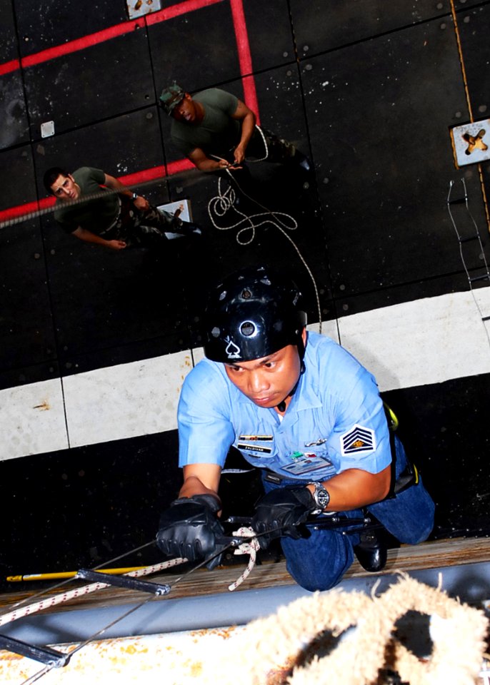 US Navy 091014-N-6692A-066 Philippine navy Petty Officer 1st Class Mark Zaldivan climbs a boarding ladder during a visit, board, search and seizure training session with U.S. Sailors aboard the amphibious dock landing ship USS