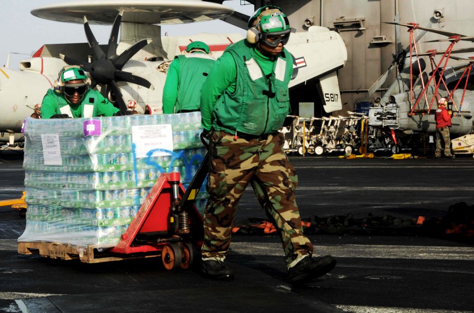US Navy 091015-N-3038W-118 Logistics Specialist Seaman Jermain Glaze, left, and Logistics Specialist 3rd Class Kevin Doss transport soda aboard the aircraft carrier USS Nimitz (CVN 68)