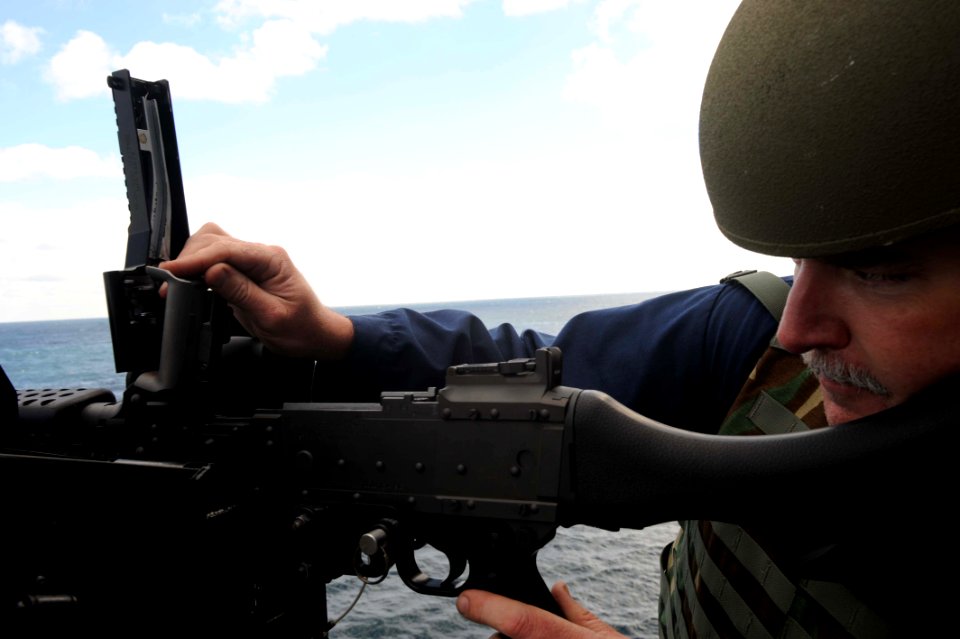 US Navy 091017-N-2147L-003 Chief Gunner's Mate Richard Daue checks the barrel of an M-240 machine gun after a live-fire exercise aboard the amphibious transport dock ship Pre-Commissioning Unit (PCU) New York (LPD 21