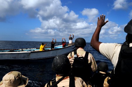 US Navy 091015-N-4154B-051 Members of a visit, board, search and seizure team from the guided-missile cruiser USS Anzio (CG 68) instruct the crewmembers of a vessel to show their hands as the team approaches to conduct a boardi