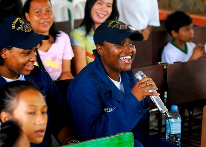 US Navy 091015-N-0807W-141 Quartermaster Seaman Sheena L. Williams, assigned to the amphibious dock landing ship USS Harpers Ferry (LSD 49), sings karaoke songs with students and teachers at West Central Elementary School