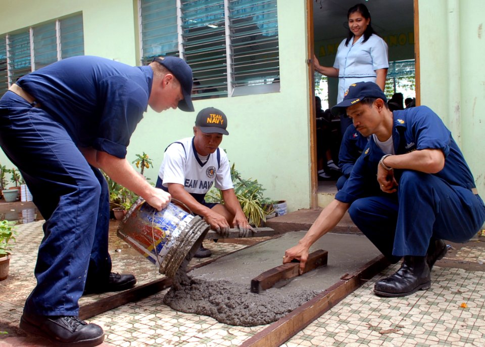 US Navy 091015-N-6692A-092 Chief Master-at-Arms Randy Bell, Senior Chief Culinary Specialist Albert Puyot and a sailor from the Philippines navy pour a new concrete walkway during a Amphibious Landing Exercise (PHIBLEX) 2009 co