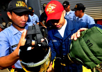 US Navy 091019-N-0807W-114 Damage Controlman Fireman Matthew C. Barrera, assigned to the amphibious dock landing ship USS Harpers Ferry (LSD 49), shows Philippine sailors how to attach a canteen to an MCU-2P gas mask