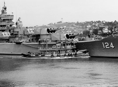 USS Awatobi (YTB-264) assists USS Rochester (CA-124) in departing Mare Island Naval Shipyard on 20 September 1953 (NH 84584)