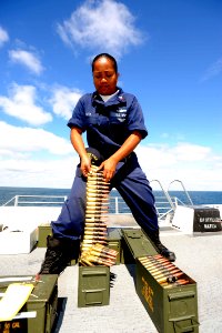 US Navy 091017-N-2147L-005 Gunner's Mate 2nd Class Mindy Tutti prepares .50-caliber rounds for a live-fire exercise from the flight deck aboard the amphibious transport dock ship Pre-Commissioning Unit (PCU) New York (LPD 21)