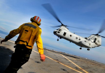US Navy 091020-N-0807W-406 Aviation Boatswain's Mate (Handling) Airman Zachary D. Bruton signals to a Marine Corps CH-46 Sea Knight helicopter aboard the amphibious dock landing ship USS Harpers Ferry (LSD 49)