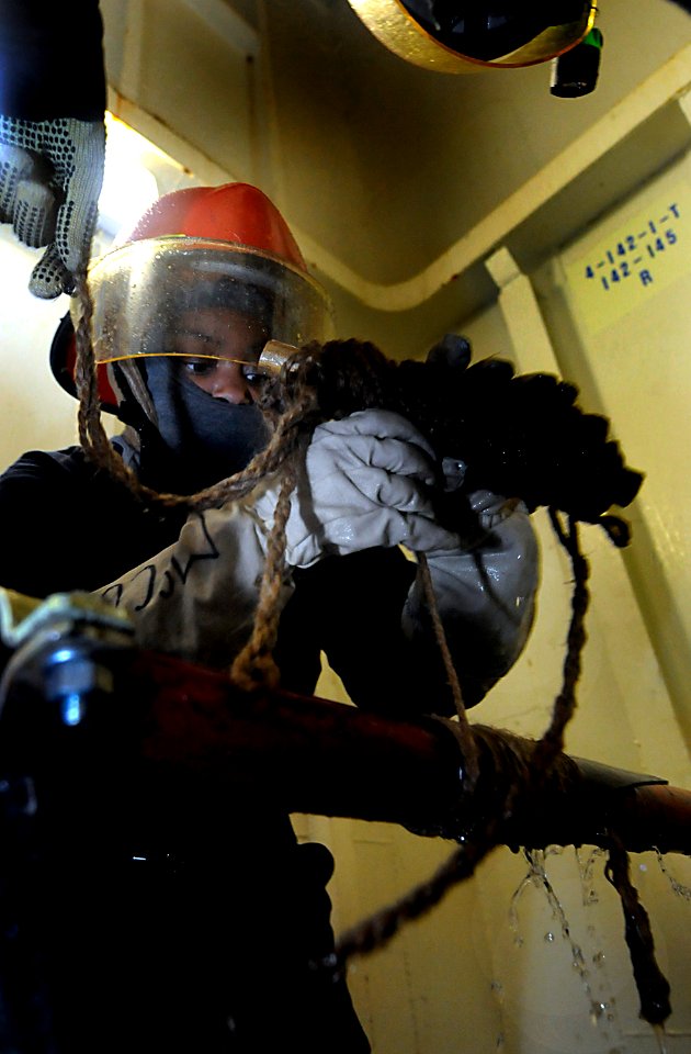 US Navy 091019-N-7280V-237 Flying squad team member Information Systems Technician 3rd Class Jonetta McCoy places a soft patch on a firemain pipe during a flooding drill aboard the amphibious command ship USS Blue Ridge (LCC 19 photo