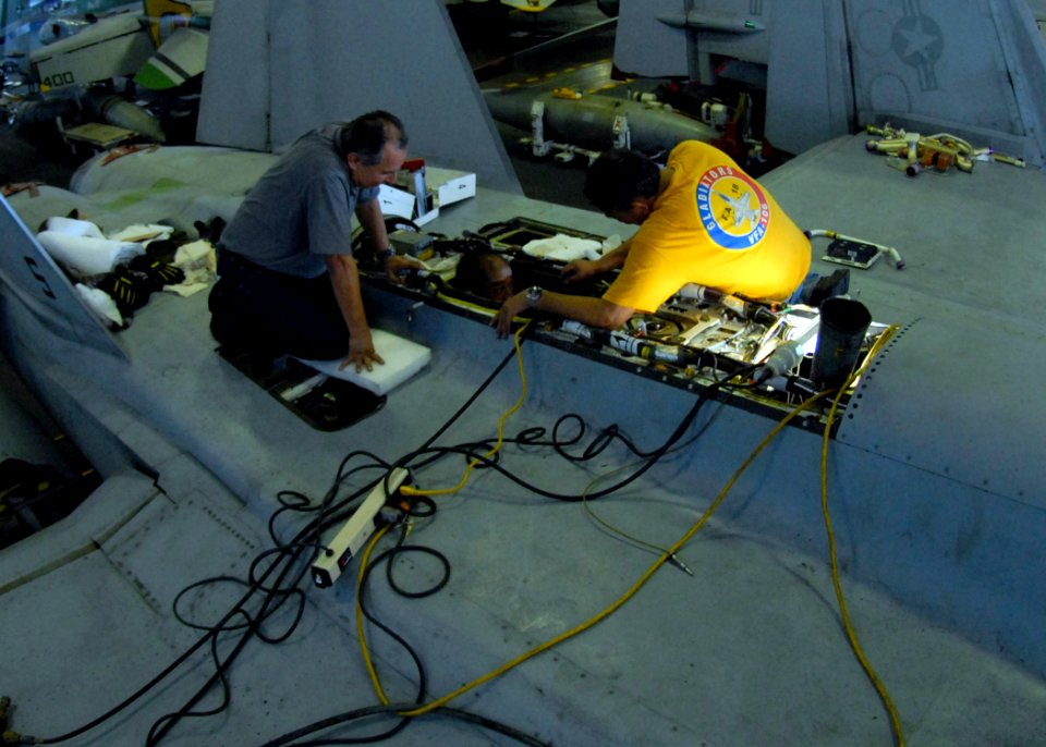 US Navy 091022-N-1644H-031 Frank Guerrero, Day Lansangan and Eddie Gutierrez from Fleet Readiness Center Southwest perform maintenance checks on an F-A-18E Super Hornet in the hangar bay aboard the aircraft carrier USS George W