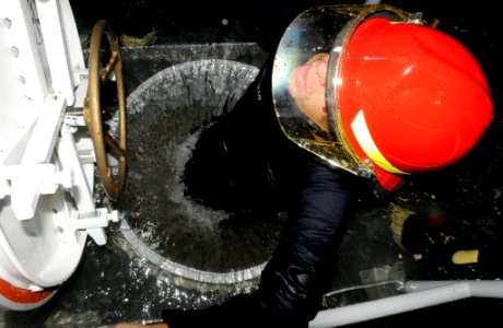 US Navy 091020-N-7498L-103 Damage Controlman 2nd Class Ken Wiseman climbs up a flooded hatch during damage control training at the Center of Naval Engineering Learning Site Pearl Harbor