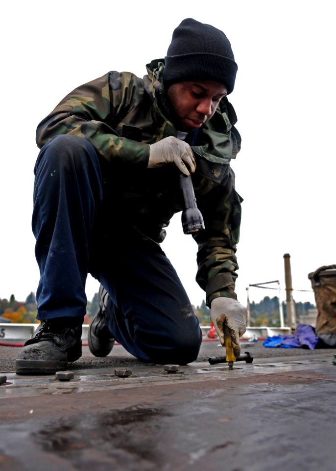 US Navy 091022-N-9928E-022 Aviation Boatswain's Mate (Equipment) Airman William Buck, from Virginia Beach, Va., repairs a barrel nut on catapult four on the flight deck aboard the aircraft carrier USS John C. Stennis (CVN 74)