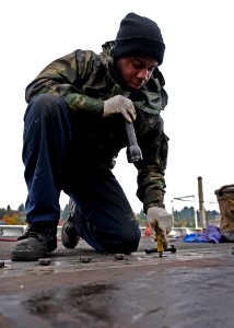 US Navy 091022-N-9928E-022 Aviation Boatswain's Mate (Equipment) Airman William Buck, from Virginia Beach, Va., repairs a barrel nut on catapult four on the flight deck aboard the aircraft carrier USS John C. Stennis (CVN 74)