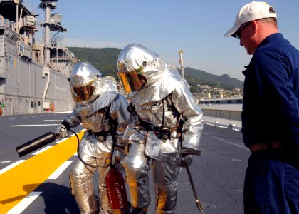 US Navy 091021-N-9950J-202 Aviation Boatswain's Mate (Handling) 3rd Class Araminta McIntosh, left, and Aviation Boatswain's Mate (Handling) Airman Chad Dornbusch participate in a fire drill
