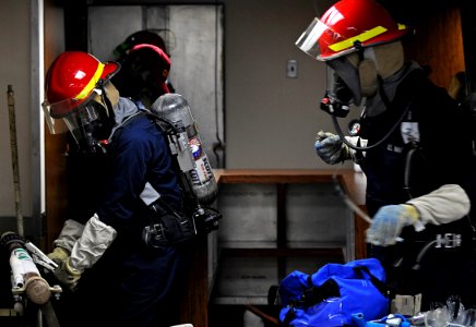 US Navy 091021-N-7280V-368 Yeoman 3rd Class Kristopher Phay and Boatswain's Mate 3rd Class Walter Johnson apply a banding patch to a simulated ruptured firemain during a general quarters drill aboard the amphibious command ship