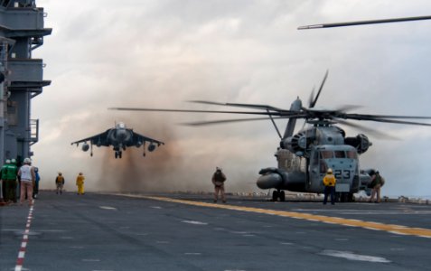 US Navy 091026-N-5319A-025 An AV-8 Harrier from Marine Attack Squadron (VMA) 223 lands next to an MH-53E Sea Dragon helicopter aboard the amphibious assault ship USS Nassau (LHA 4) during flight operations