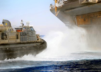 US Navy 091022-N-7508R-149 A landing craft air cushion from Assault Craft Unit (ACU) 4 exits the well deck of multipurpose amphibious assault ship USS Bataan (LHD 5) to conduct routine operations in the Gulf of Aqaba photo