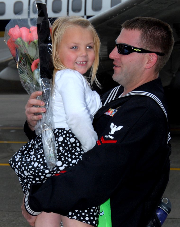 US Navy 091021-N-9860Y-006 Aviation Structural Mechanic (Safety Equipment) 2nd Class Brett Bingham hugs his daughter during the squadron's homecoming to the Naval Air Station Whidbey Island