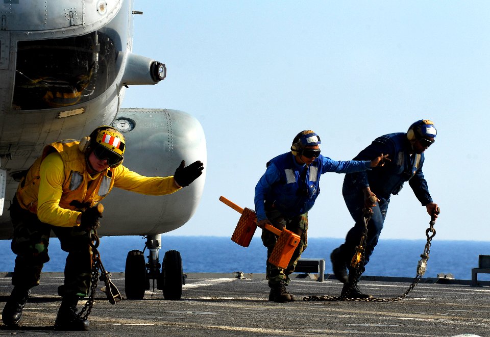 US Navy 091027-N-0807W-656 Sailors assigned to the amphibious dock landing ship USS Harpers Ferry (LSD 49) retrieve chocks and chains from a Marine Corps CH-46 helicopter