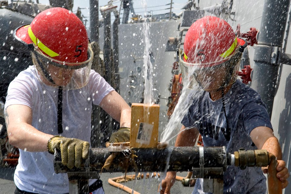 US Navy 091025-N-9123L-001 Culinary Specialist Seaman Dylan Smith, from St. Louis, Mo., and Boatswain's Mate 2nd Class Preston Rodgers, from Odessa, Texas, patch a ruptured pipe during a damage control Olympics event