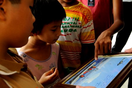 US Navy 091027-N-3830J-307 Children from the Praise Emmanuel Children's Home look at a picture presented to the home by Sailors assigned to the amphibious command ship USS Blue Ridge (LCC 19)