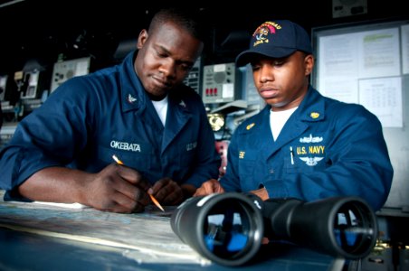 US Navy 091024-N-5319A-002 Quartermaster 3rd Class Oscar Okebata, left, from Philadelphia, and acting junior Officer of the Deck Chief Operations specialist Duran Lee, from West Point, Miss., read the chart table aboard the amp