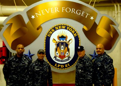 US Navy 091029-N-0924R-061 Sailors from New York pose around the crest of the amphibious transport dock ship Pre-Commissioning Unit (PCU) New York (LPD 21)