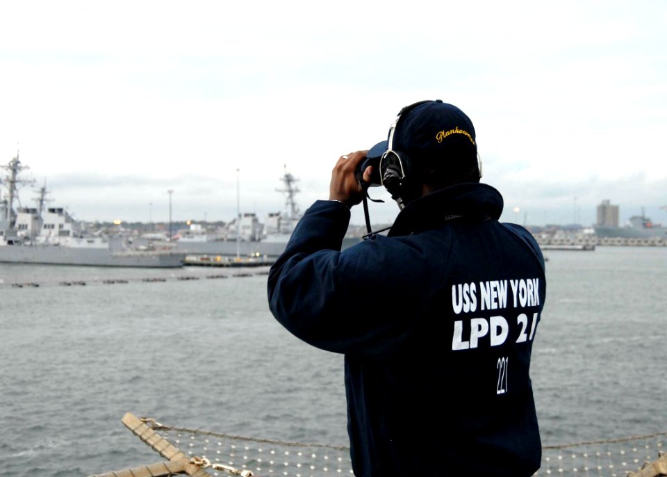 US Navy 091029-N-0924R-020 Seaman Marquis Emanuel looks out over the piers of Naval Station Norfolk from the flight deck of the amphibious transport dock ship Pre-Commissioning Unit (PCU) New York (LPD 21)