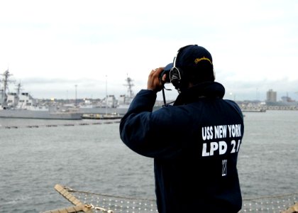 US Navy 091029-N-0924R-020 Seaman Marquis Emanuel looks out over the piers of Naval Station Norfolk from the flight deck of the amphibious transport dock ship Pre-Commissioning Unit (PCU) New York (LPD 21)