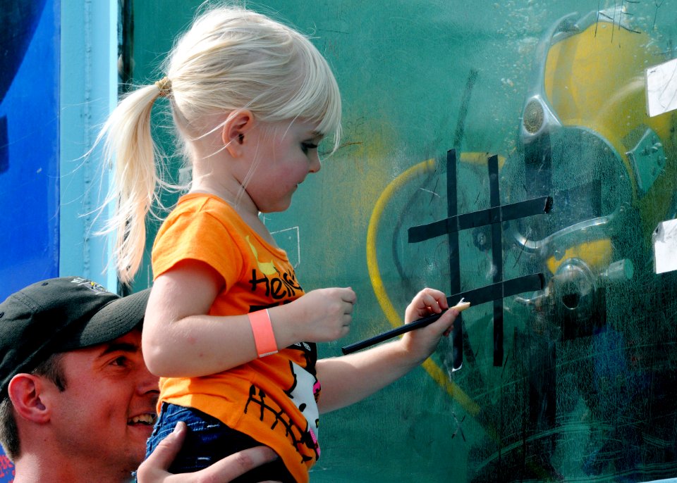 US Navy 091024-N-4267W-023 A young girl at the Driver Days festival in Driver, Va., plays a Navy diver in a game of Tic-Tack-Toe